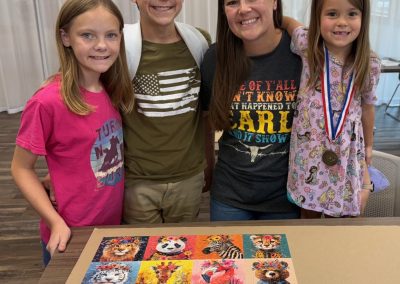 Four people standing behind a table with a completed animal-themed puzzle.